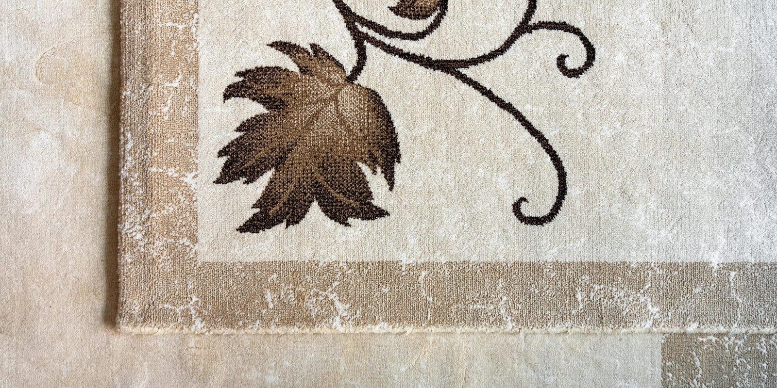 Close-up of an elegant floral pattern on a textured beige rug enhancing interior decor.